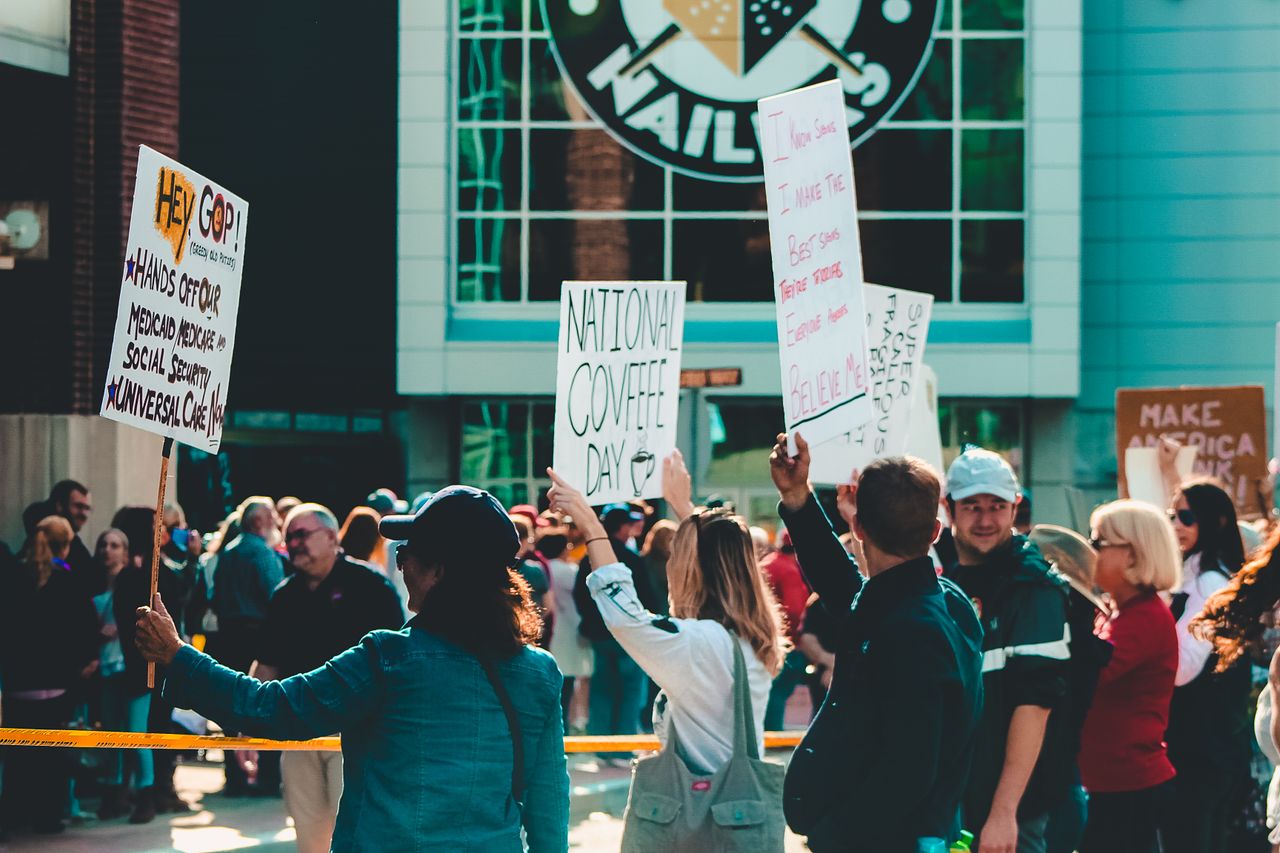 Vibrant scene of people demonstrating outdoors with signs advocating political messages.
